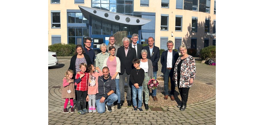 Auf dem Bild erkennt man eine  Gruppe von Menschen die vor der Kreisverwaltung Mainz-Bingen in Ingelheim stehen.